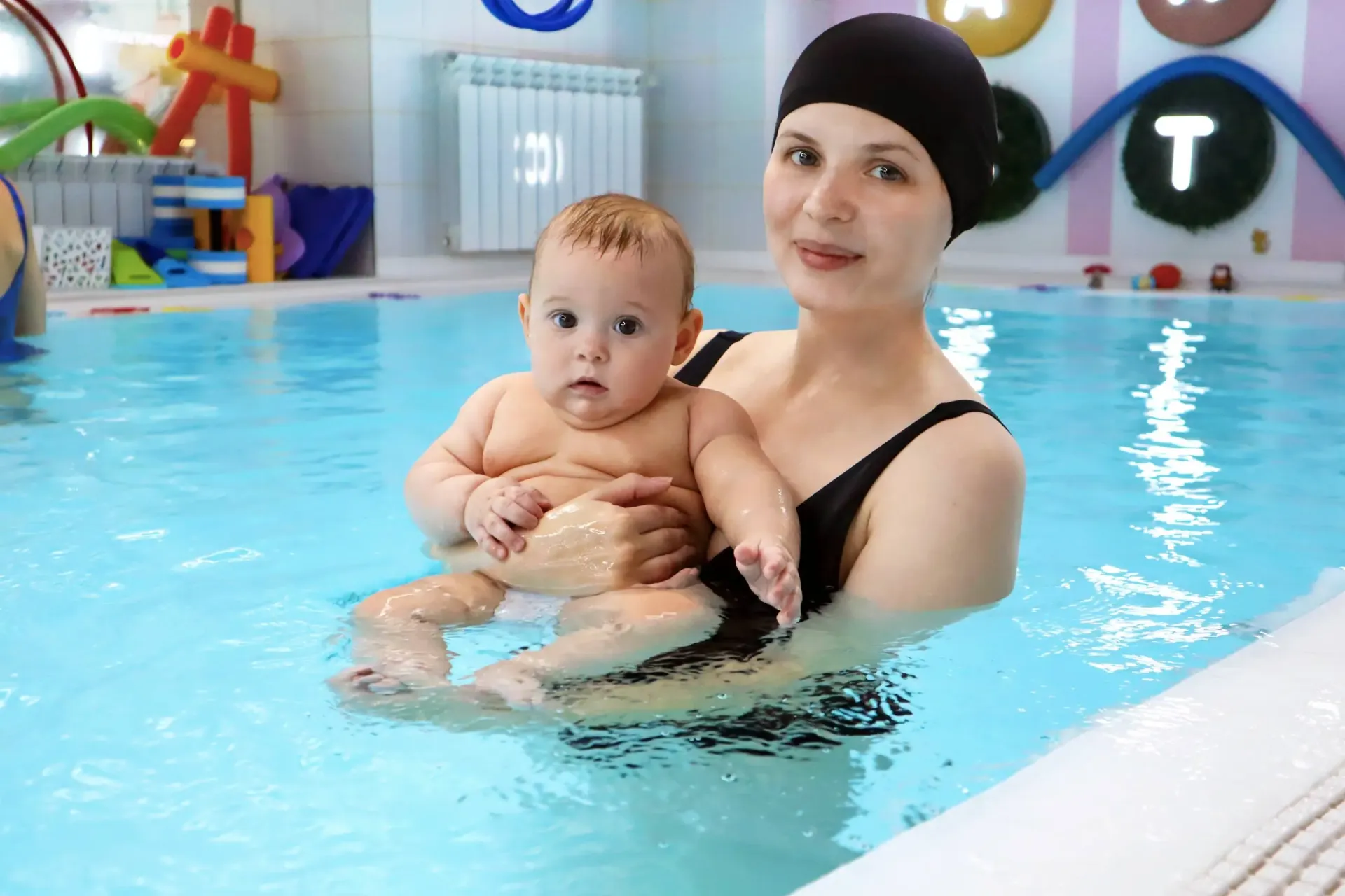 Инструктор занимается с малышом в бассейне АкваСтар
